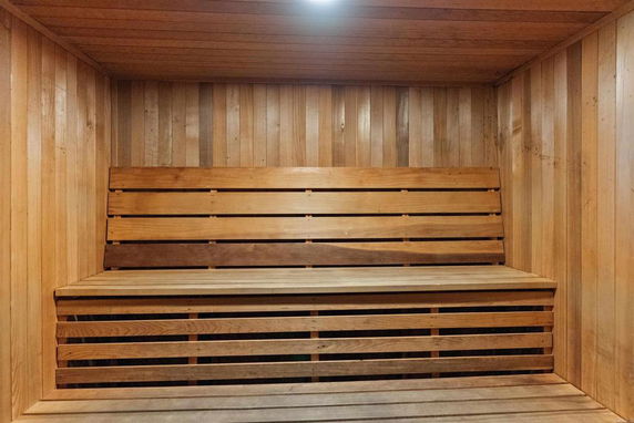 Interior view of a wooden sauna room with bench seating.