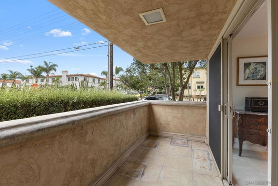 View from a patio or balcony of a residential area with distant houses and trees.
