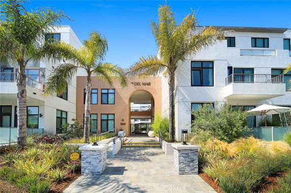 Front view of a modern multi-story building with palm trees.