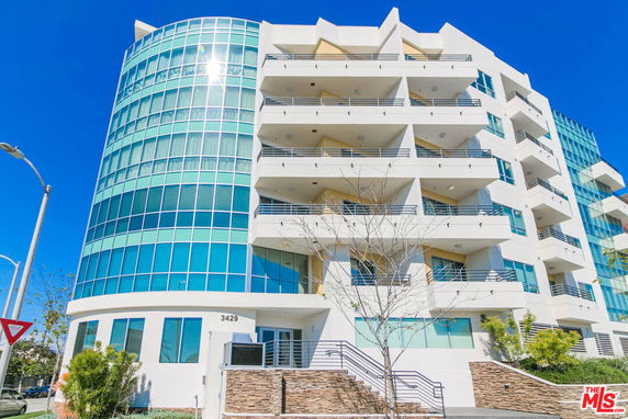 Front view of a modern multi-story building with glass and concrete facade.