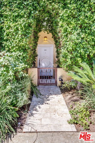 Front view of a house entrance surrounded by greenery.