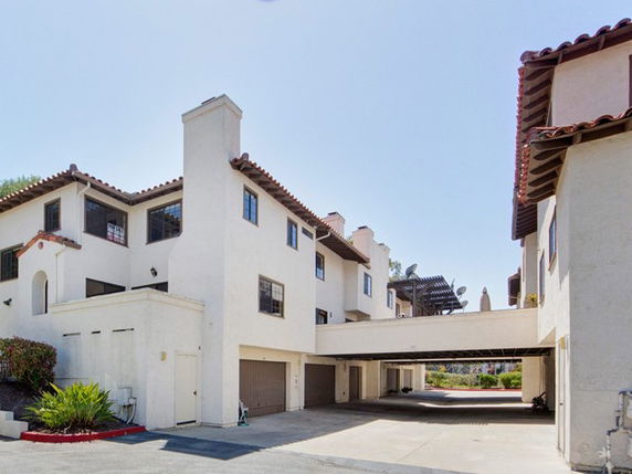 Front view of a multi-story building with an attached garage and archways.