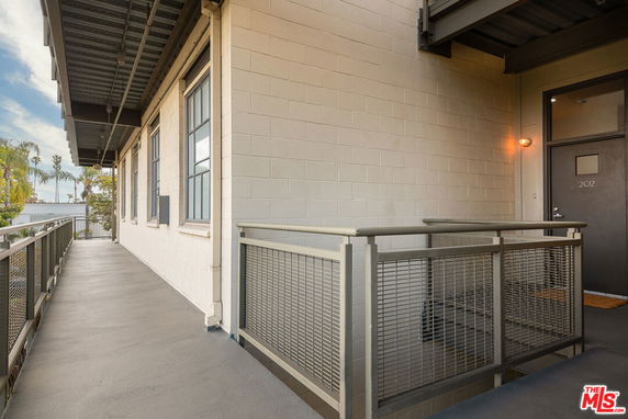 Exterior view of a building entrance with a metal railing and door number 202.