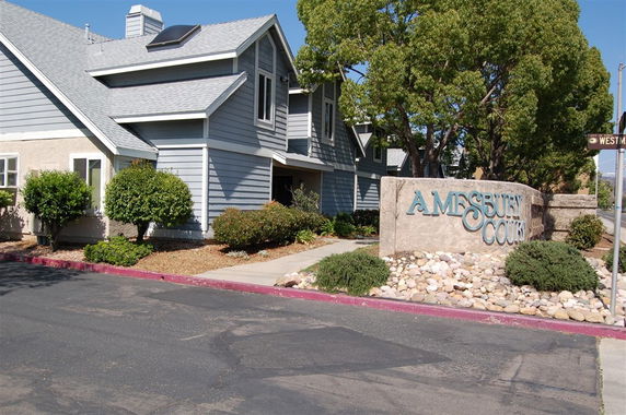 Front view of a multi-story residential building with a sign reading 'Amesbury Court'.