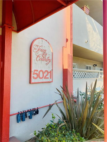 Front view of a building entrance with red trim and a sign reading 'Town & Country 5021'.