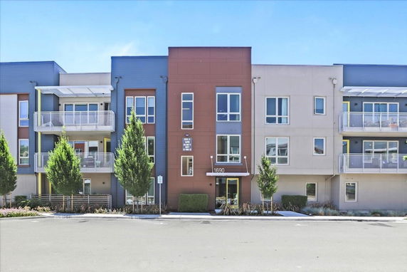 Front view of a modern multi-story apartment building with balconies.