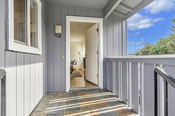 Entrance view of a house with a gray exterior and open door leading inside.