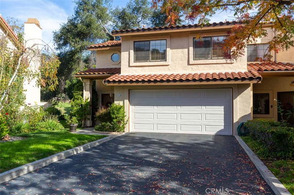 Front view of a two-story house with a double garage and tiled roof.