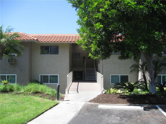 Front view of a two-story building with a staircase leading to the entrance