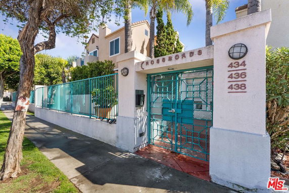 Front view of a residential building with gated entry and multiple addresses displayed.
