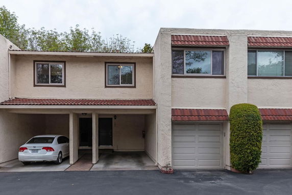 Front view of a two-story house with a carport and garage.
