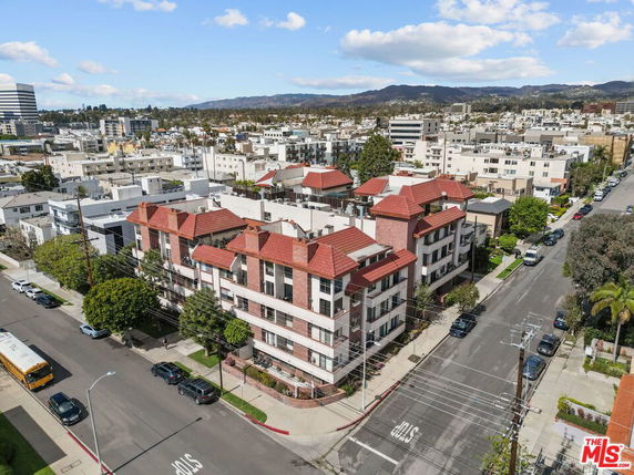 Aerial view of a multi-story apartment building with red roofs.