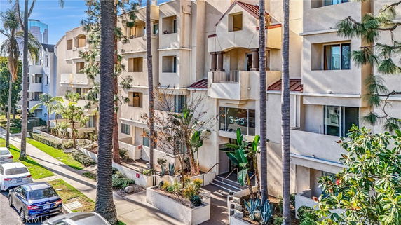 Front view of a multi-story apartment building with balconies and entrance.