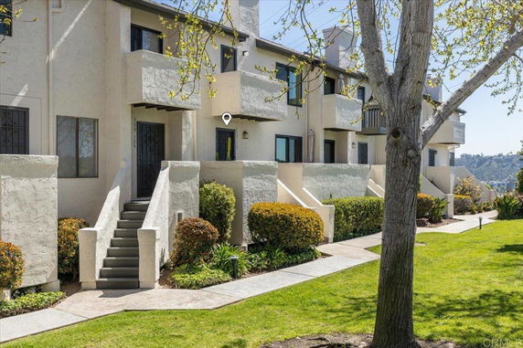 Front view of a multi-story townhouse with stairways leading to entrances.