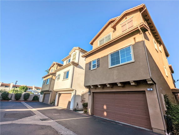 Front view of multi-story townhouses with garages on the ground level.