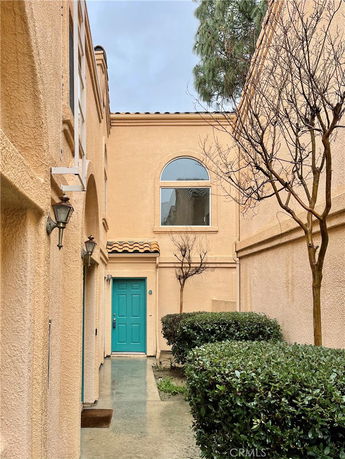 Entrance view of a building with a turquoise door and arched window.