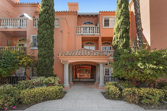 Front view of a multi-story building with balconies and decorative columns.