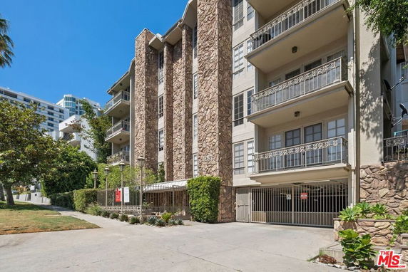 Front view of a multi-story building with balconies and stone accents.