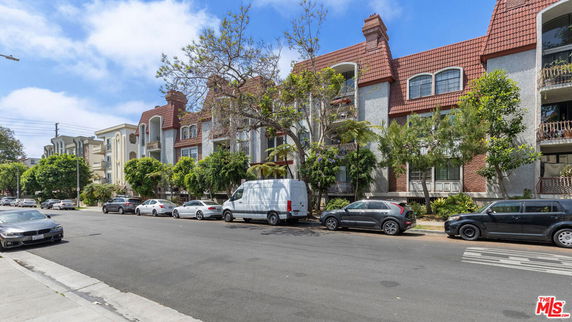 Front view of a multi-story residential building with red gabled roofs and balconies.
