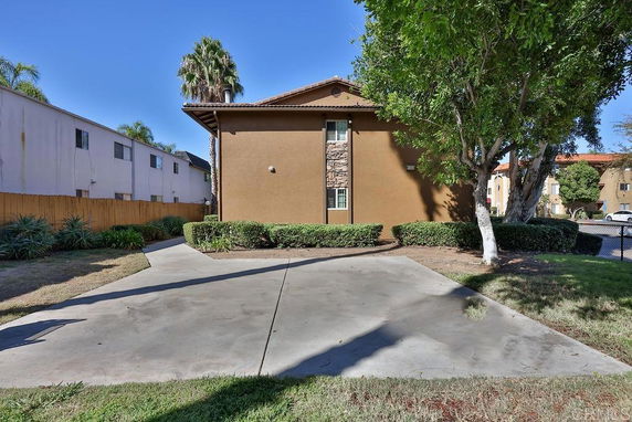 Side view of a two-story building with surrounding driveway and landscaping.