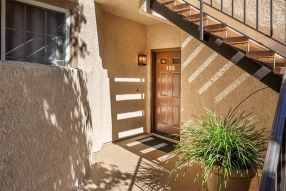Entrance view of a residential building unit with stairs leading upward.