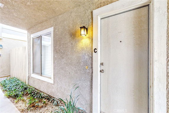 Front view of an entrance door with a window and exterior lighting.