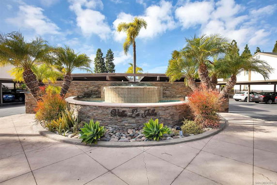 Outdoor parking area with decorative fountain and surrounding plants