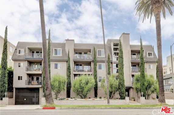 Front view of a multi-story apartment building with balconies.