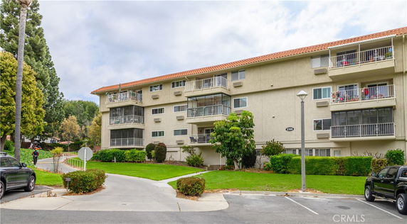 Front view of a four-story apartment building with balconies.