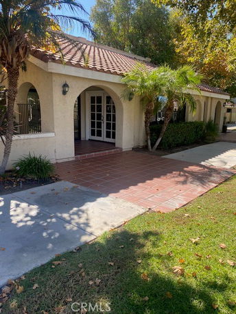 Front view of a single-story building with arched doorways and a tiled roof.