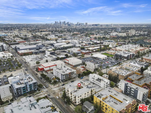 Wide-angle aerial view of a cityscape with multiple buildings and a distant skyline.