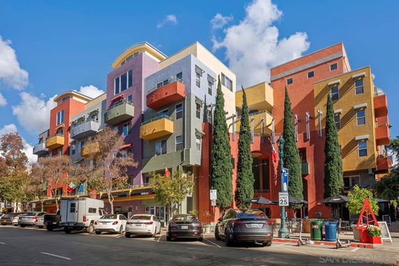 Front view of a colorful multi-story building with balconies.
