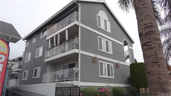 Front view of a multi-story building with balconies and arched windows.