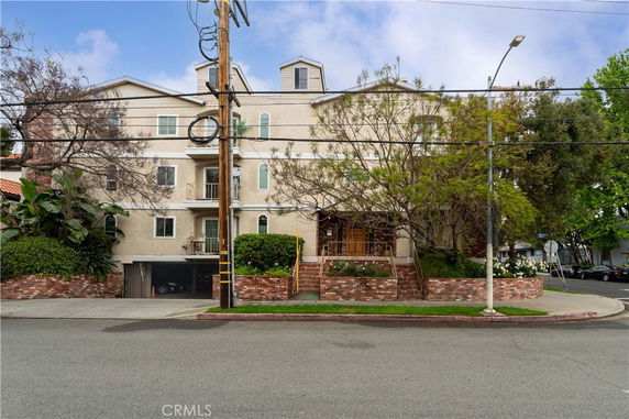 Front view of a multi-story residential building with a garage entrance at the ground level.
