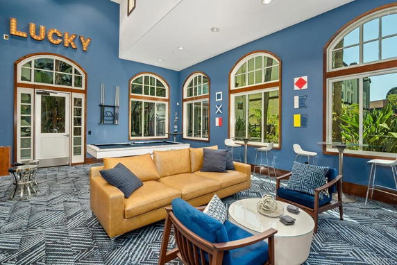 Recreation area with a pool table and seating, featuring blue walls and decorative elements.