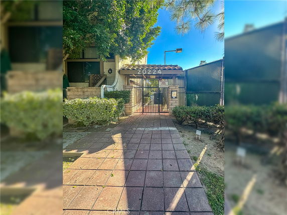 Front view of a building entrance with a gate and house number displayed above.