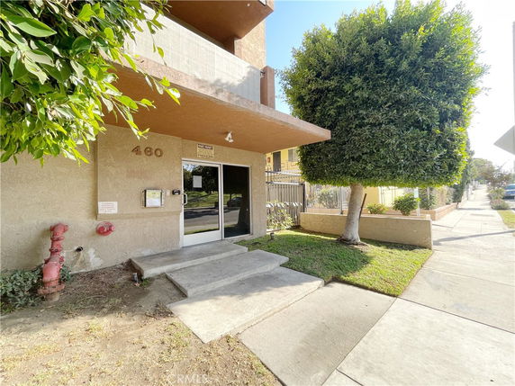 Front view of a building entrance with steps and a glass door.
