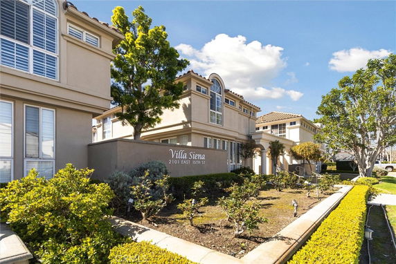 Front view of a multi-story residential building with landscaped garden.