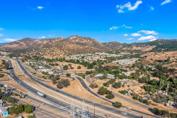 Wide-angle view of a highway with surrounding hills and sparse vegetation.