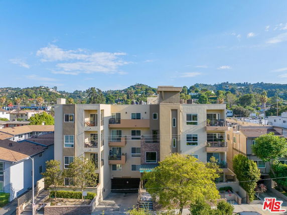 Front view of a multi-story apartment building with balconies.