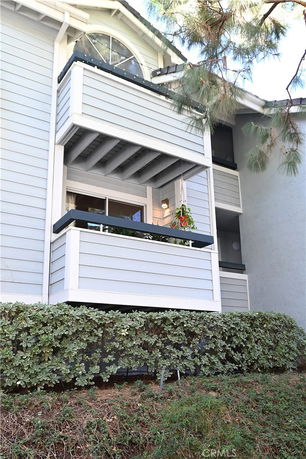 Front view of a building with a small balcony and overhanging roof.