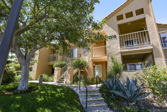 Front view of a two-story residential building with balconies and stairs.