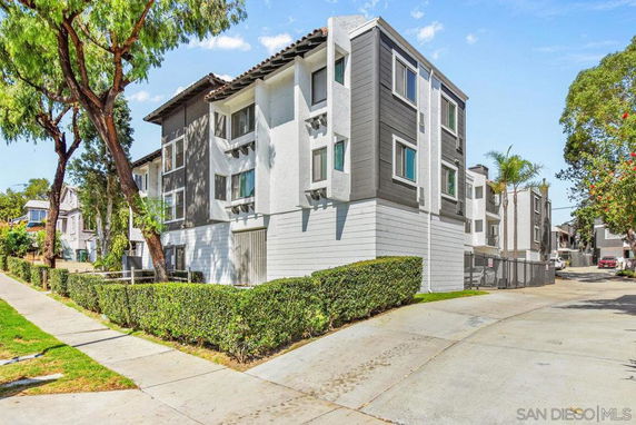 Front view of a multi-story residential building with a white and gray exterior.