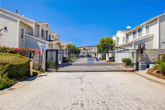 Front view of a gated residential community with two-story houses.