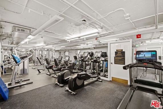 Indoor gym area with various exercise machines and equipment.