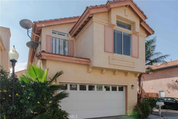 Front view of a two-story house with a double garage and satellite dishes.