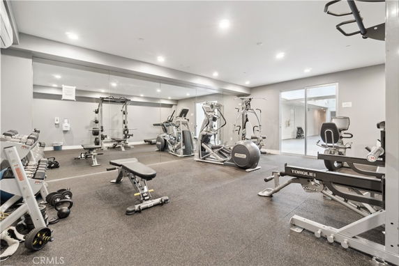 Indoor gym area equipped with various exercise machines and weights.
