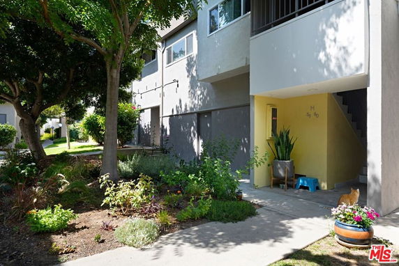 Front view of a multi-story building with an entrance and garden area.