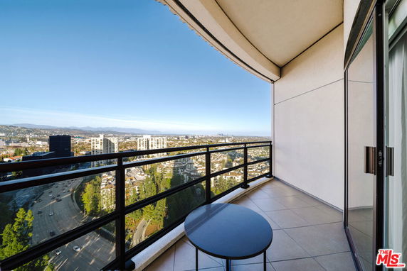Panoramic view from a high-rise balcony overlooking the cityscape.