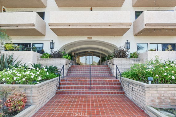 Front view of a building with stairs leading to an entrance.